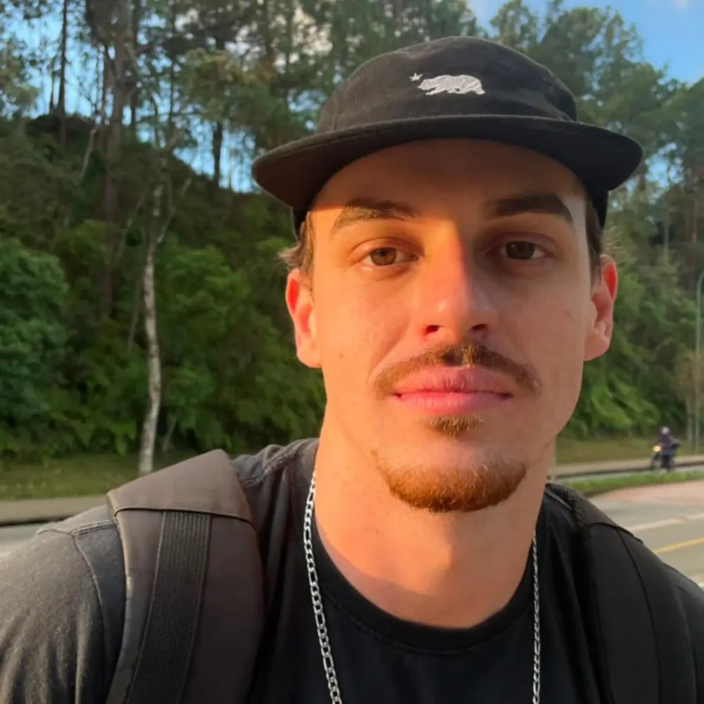O Prof. Guilherme de boné e corrente, com olhar de quem sabe o horário que o marido chega